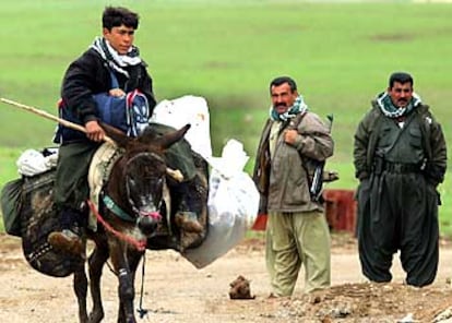 Un joven a lomos de un burro pasa un control en el Kurdistán iraquí. La guerrilla se ha desplegado en el norte de Irak bajo control kurdo, desde el inicio del ataque estadounidense.