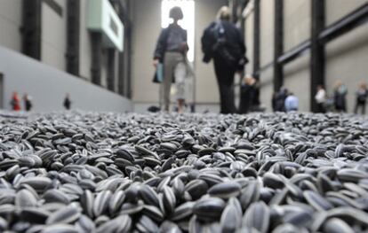 Visitantes de la Tate Modern caminan sobre las pipas de porcelana que componen la instalación <i>Sunflower seeds</i> .