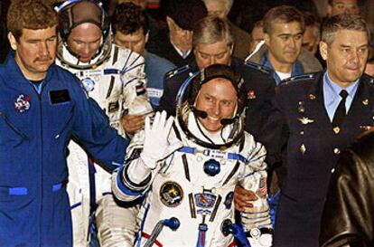 Michael Fincke saluda antes de entrar en la <i>Soyuz.</i> Detrás, el holandés André Kuipers.