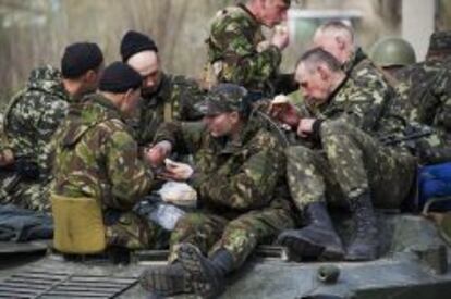 Soldados ucranianos comen subidos a un vehículo blindado en Kramatorsk.