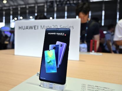 People look at the new Huawei smartphones at the company stand during the Consumer Electronics Show, Ces Asia 2019 in Shanghai on June 11, 2019. (Photo by HECTOR RETAMAL / AFP)