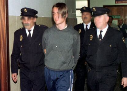 El joven, custodiado por agentes de la Policía tras ser detenido en Murcia en 2000.