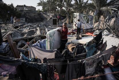 Un palestino recoge un colchón de los escombros tras el ataque israelí, este martes.