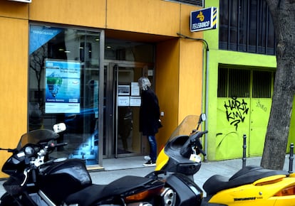 A man reads the coronavirus measures on signs at a branch of Targo Bank in Madrid.