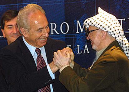 Yasir Arafat (derecha) y Simón Peres se saludan durante el Foro Formentor.