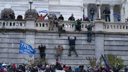 Los partidarios del presidente Donald Trump escalan el muro oeste del Capitolio de los Estados Unidos.
