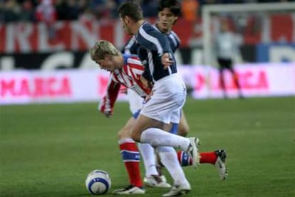 Torres intenta internarse entre dos jugadores del Numancia.