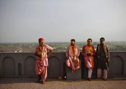 Unos hombres se toman un descanso tras celebrar el festival Holi en la ciudad india de Nandgaon, 28 de febrero de 2015.