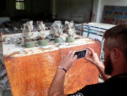 Un visitante toma una fotografía de máscaras antigás en una antigua base del ejército soviético, cerca de la Central Nuclear de Chernóbil.