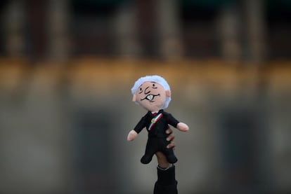 Una mano sostiene un muñeco 'Amlito' durante la celebración de los 5 años del triunfo de Morena en las elecciones.