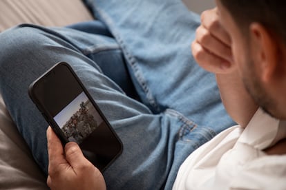 Barco mira en su celular fotografías de su etapa en el ejército.