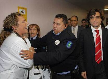 Un vigilante de seguridad agarra a una trabajadora que protesta por la situación del hospital de Getafe durante la visita de Juan José Güemes.