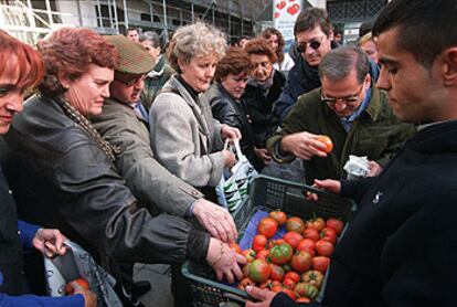 Agricultores reparten tomates gratis, ayer, en una calle del centro de Madrid.