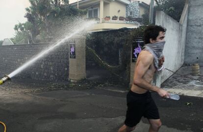 Un hombre corre mientras el fuego se acerca a las casas en Funchal, isla de Madeira.