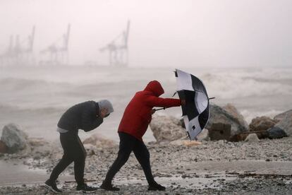 Um homem com um guarda-chuva protege-se do forte vento na praia Seacaba de Málaga, na sexta-feira, 8 de janeiro.