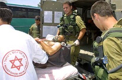 Un palestino herido es retirado en ambulancia por varios paramédicos israelíes, cerca de Jerusalén.