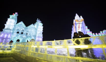 Visitantes en un puente de la ciudad de hielo construída durante el festival internacional de Harbin. 