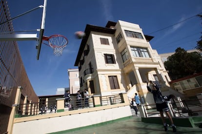 Un alumno practica baloncesto en un colegio.