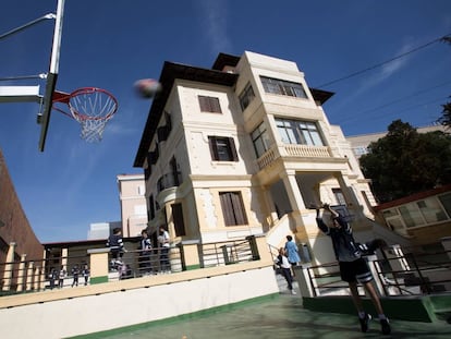 Un alumno practica baloncesto en un colegio.