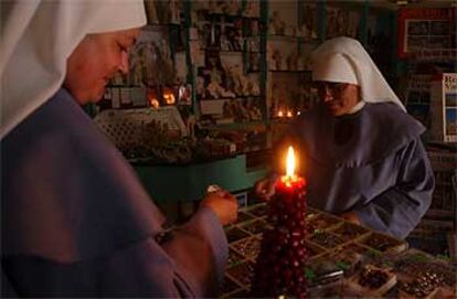 La ausencia de luz no ha evitado que las tiendas abran. En este establecimiento dedicado a la venta de recuerdos religiosos en Roma, las velas han permitido continuar con la actividad diaria.