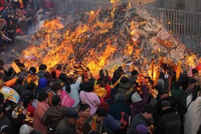 Un grupo de peregrinos arrojan ofrendas en una hoguera durante una feria en el templo de la tumba de Tai Hao, en Zhoukou, en la provincia central de Henan (China).