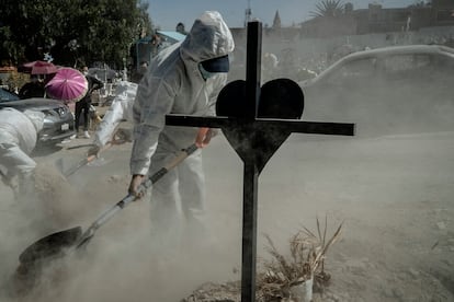 Trabajadores de un panteón en Ecatepec (México), sepultan a un hombre que murió de coronavirus, en febrero de 2021.