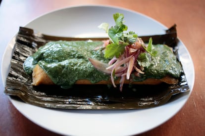 Tamal peruano relleno de cerdo y olivas con curry verde y ensalada criolla.