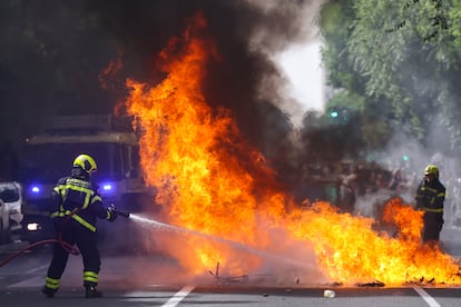 Los bomberos apagan un contenedor incendiado, este miércoles en Cádiz.