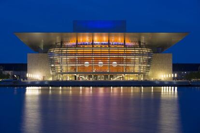 El teatro nacional de ópera de <a href="https://elviajero.elpais.com/tag/dinamarca/a" target="_blank">Dinamarca</a>, considerado uno de los más modernos (y costosos) del mundo, ocupa 41.000 metros cuadrados, y cinco de sus catorce pisos son subterráneos. En realidad, la Ópera Real de Copenhague está formada por dos sedes: la antigua, que ha quedado para conciertos y obras del barroco, y el moderno edificio, inaugurado en 2005, revestido con piedra caliza Jura Gelb del sur de Alemania y con mármol siciliano Perlatino en su vestíbulo; el techo del auditorio principal está adornado con 105.000 hojas de pan de oro de 24 quilates (kilo y medio de oro en total). Es una donación de la Fundación A.P. Møller y Chastine McKinney Møller al pueblo danés, y fue diseñado por el arquitecto danés Henning Larsen.