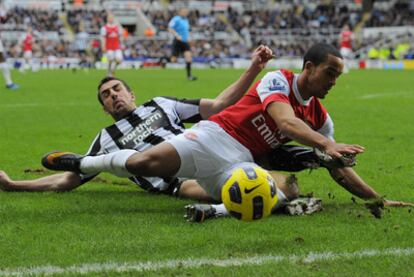 José Enrique y Theo Walcott luchan por el balón