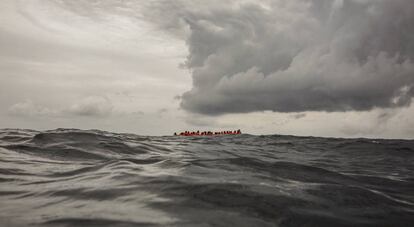 Migrantes a bordo de un bote que partió de Libia aguardan su rescate en el Mediterráneo Central. 