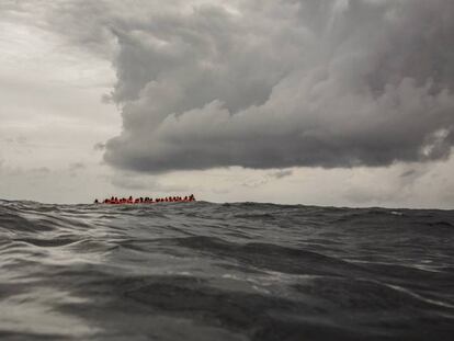 Migrantes a bordo de un bote que partió de Libia aguardan su rescate en el Mediterráneo Central. 