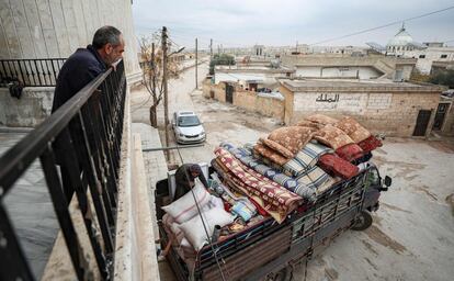 Abu Bilal observa desde un balcón cómo un camión se lleva sus pertenencias tras los recientes ataques militares en la provincia de Idlib.