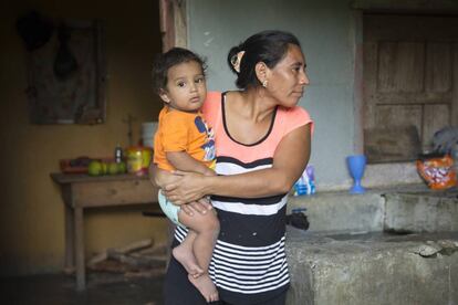 Edis esposa de Manuel sujeta en brazos a su nieto Anthony en su pequeña casa en Honduras.