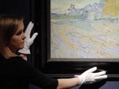 Una empleada de la casa de subastas Christie's muestra la pintura "Vue de l'asile et de la Chapelle de Saint-Remy", del pintor holandés Vincent Van Gogh