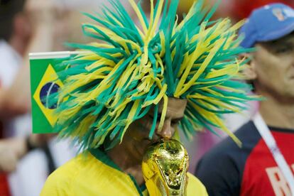 Un aficionado brasileño besa cabizbajo una réplica del trofeo de campeón del mundo durante el partido de su selección frente a Suiza, que acabó en empate a uno, en el Rostov Arena de Rusia, el 17 de junio.