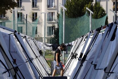 Un migrante pasa junto a unas tiendas de campaña desplegadas en un campo instalado dentro del campus de la universidad de Pantheon-Assas en París (Francia).