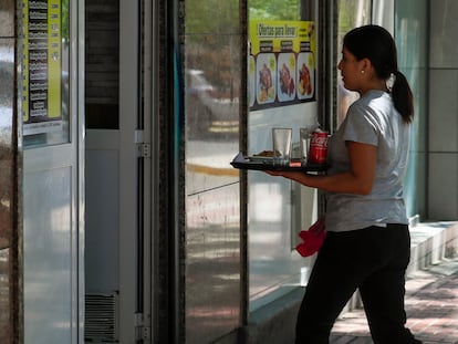 Una camarera retira un servicio en una cafetería de Madrid.