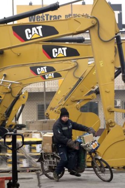 Un hombre pasa junto a unas máquinas de Caterpillar, en Pekín.