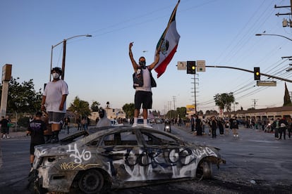 Un manifestante ondea la bandera de México subido a un coche calcinado, el pasado 7 de junio en Los Ángeles