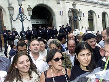 Tumulto ante el Ayuntamiento de Valence (Francia). A la derecha, Malika con un ramo de flores. PLANO GENERAL - ESCENA