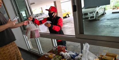 Un repartidor de comida a domicilio enrega un pedido a un cliente en Bangkok (Tailandia). 