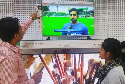 An employee (L) gives a customer an overview of LG Electronics' world¡¯s first mosquito-repelling TV at an electronic shop in Delhi, India, in this undated photo provided by the company and released by Yonhap on June 16, 2016. LG Electronics/Yonhap via REUTERS. ATTENTION EDITORS - THIS IMAGE HAS BEEN SUPPLIED BY A THIRD PARTY. SOUTH KOREA OUT. FOR EDITORIAL USE ONLY. NO RESALES. NO ARCHIVE.