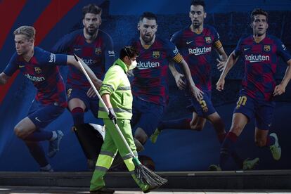 Un barrendero trabaja este sábado en las puertas del estadio Camp Nou en Barcelona que permanece cerrado al público.