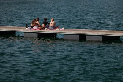 Un grupo de jóvenes toma el sol en la marina de Valencia, el pasado miércoles.