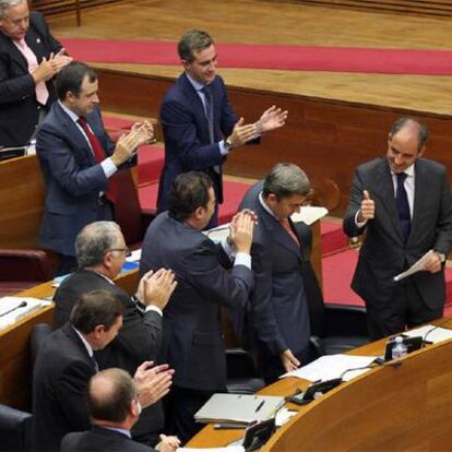 Camps recibe el aplauso de consejeros y diputados populares, ayer, en las Cortes.