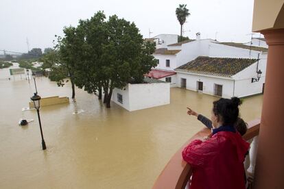 Una mujer observa las casas inundadas en la barriada Doña Ana de la localidad de Cártama (Málaga) por las fuertes lluvia caídas esta noche.