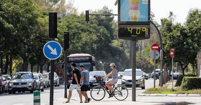 Varias personas pasan ante un termómetro urbano en Valencia el pasado sábado.