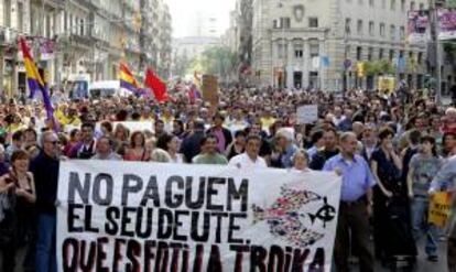 Varias personas sostienen una pancarta durante la manifestación contra la "troika" que esta tarde ha recorrido las calles de Barcelona.