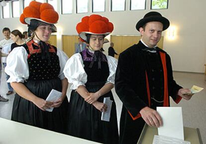 Tres ciudadanos alemanes, ataviados con trajes regionales de Baden-Württemberg, acuden a votar.